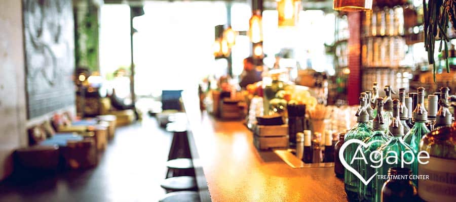 image of a bar showing liquor bottles, seating, and the bar top which may be an external relapse trigger for some
