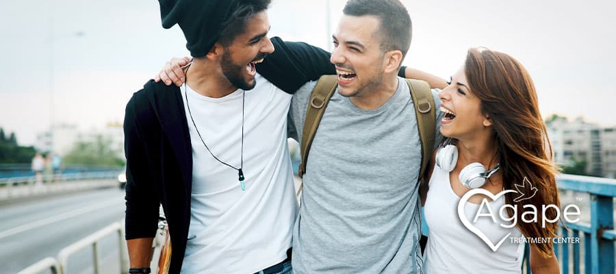 three happy friends walking outside enjoying life while in sober living