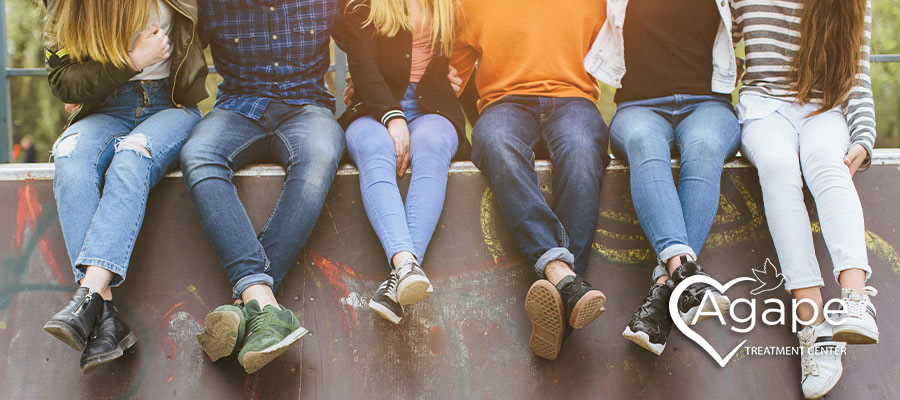coed group of young people sitting on a bench in recovery