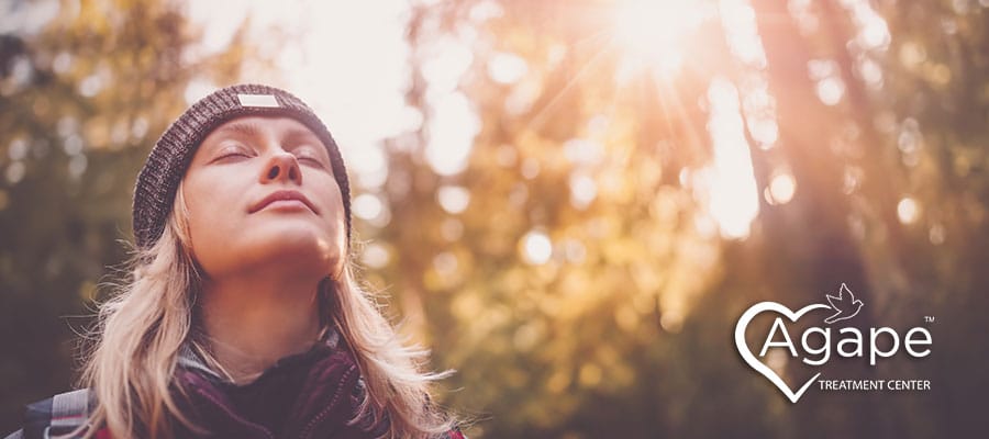 serene woman taking a walk in the woods and practicing self care